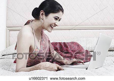 Side profile of a young woman using a laptop View Large Photo Image Stock Image - Side profile of a young woman using a laptop. Fotosearch