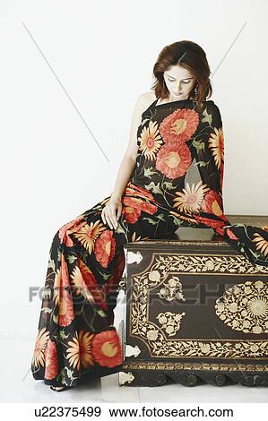 Young woman sitting on a wooden box View Large Photo Image Stock Photo - Young woman sitting on a wooden box. Fotosearch