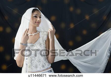 Young woman standing in lehenga choli View Large Photo Image Stock Image - Young woman standing in lehenga choli. Fotosearch