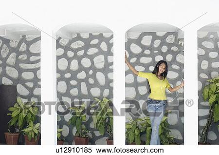 Young woman standing in the porch and listening to an mp3 player View Large Photo Image Stock Photography - Young woman standing in the porch and listening to an mp3 player. Fotosearch