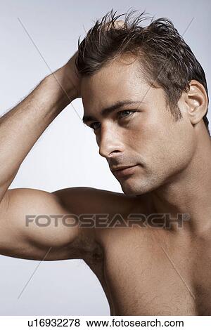 Stock Photo - Mid adult man with hand in his hair. Fotosearch