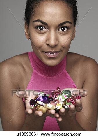 Young woman holding candies View Large Photo Image Stock Photo - Young woman holding candies. Fotosearch