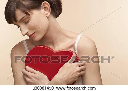 Mid adult woman holding heart shaped chocolate box View Large Photo Image Stock Image - Mid adult woman holding heart shaped chocolate box. Fotosearch