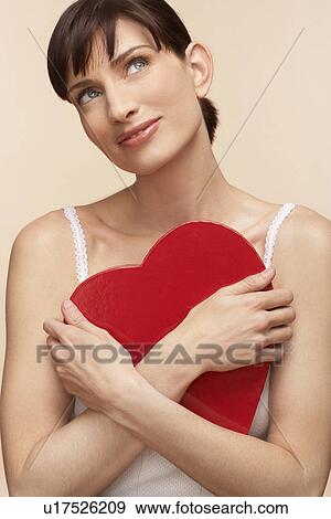 Mid adult woman holding heart shaped chocolate box View Large Photo Image Stock Photo - Mid adult woman holding heart shaped chocolate box. Fotosearch