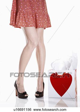 Young woman's legs near shopping bag View Large Photo Image Stock Photograph - Young woman's legs near shopping bag. Fotosearch
