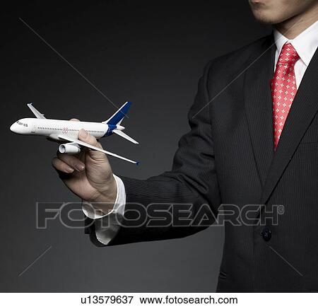Businessman Holding Airplane Model View Large Photo Image Stock Photo - Businessman Holding Airplane Model. Fotosearch