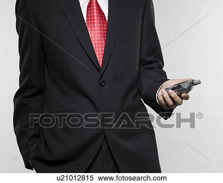 Stock Photography - Businessman Holding PDA. Fotosearch
