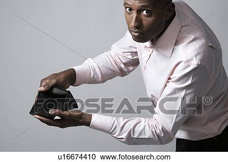 Stock Image - Businessman showing empty wallet. Fotosearch