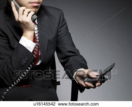 Businessman Using Landline and Mobile Phone View Large Photo Image Stock Image - Businessman Using Landline and Mobile Phone. Fotosearch