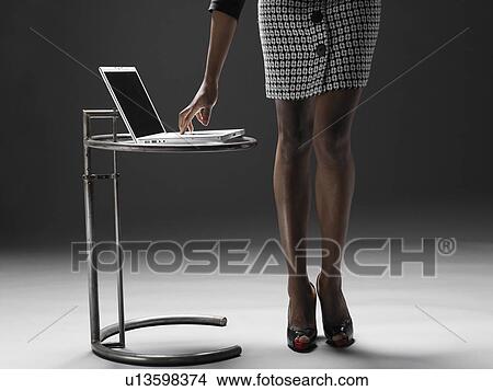 Businesswoman using laptop (low section) View Large Photo Image Picture - Businesswoman using laptop (low section). Fotosearch