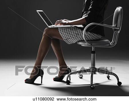 Businesswoman using laptop (low section) View Large Photo Image Stock Image - Businesswoman using laptop (low section). Fotosearch