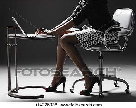 Businesswoman using laptop (low section) View Large Photo Image Stock Photo - Businesswoman using laptop (low section). Fotosearch