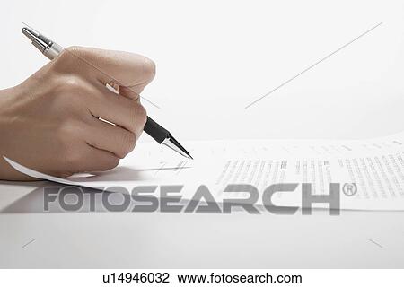 Stock Image - Woman's hand signing documents (close-up). Fotosearch
