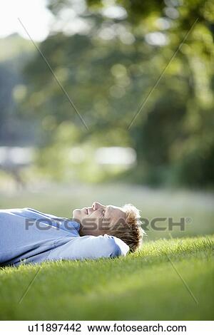 Man lying on lawn View Large Photo Image Stock Image - Man lying on lawn. Fotosearch