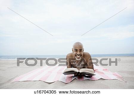 Man reading book on beach View Large Photo Image Stock Photography - Man reading book on beach. Fotosearch