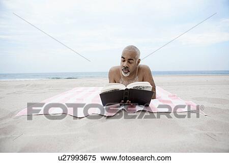 Man reading book on beach View Large Photo Image Stock Photography - Man reading book on beach. Fotosearch