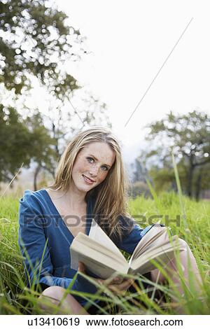 Teenage girl reading book in field View Large Photo Image Stock Photo - Teenage girl reading book in field. Fotosearch