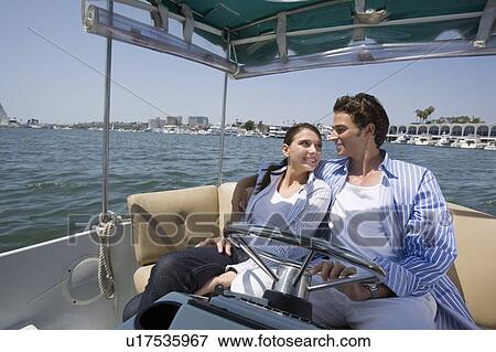 Stock Photo - Young adult couple cruising, Side View. Fotosearch
