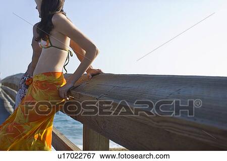 Young adult couple leaning on railing, Side View, Copy Space View Large Photo Image Stock Photo - Young adult couple leaning on railing, Side View, Copy Space. Fotosearch
