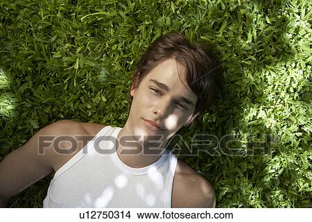 Young Man Lying on Grass View Large Photo Image Picture - Young Man Lying on Grass. Fotosearch