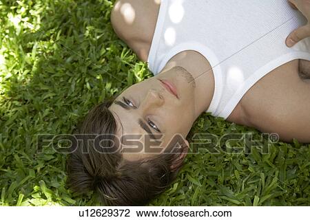 Young Man Lying on Grass View Large Photo Image Stock Image - Young Man Lying on Grass. Fotosearch
