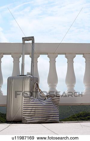 Suitcase and handbag by railings View Large Photo Image Stock Photo - Suitcase and handbag by railings. Fotosearch