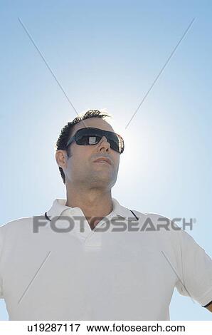 Stock Photo - Mature man against clear sky (portrait, low angle view). Fotosearch