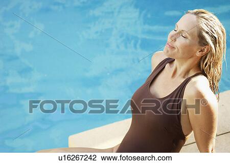 Mature woman by swimming pool (high angle view) View Large Photo Image Stock Image - Mature woman by swimming pool (high angle view). Fotosearch
