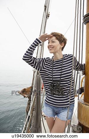 Mid adult woman looking at sea in sailboat View Large Photo Image Stock Image - Mid adult woman looking at sea in sailboat. Fotosearch