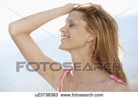 Stock Image - Mid adult woman with hand on head. Fotosearch