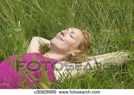 Woman sleeping on tall grass View Large Photo Image Stock Photo - Woman sleeping on tall grass. Fotosearch