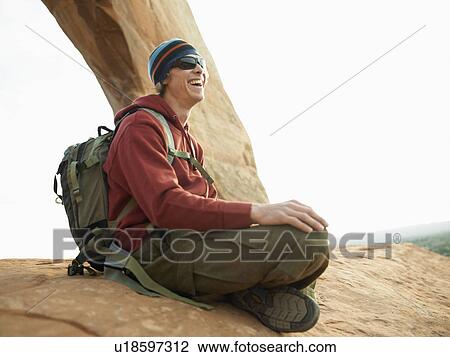 Young hiker sitting on rock View Large Photo Image Stock Image - Young hiker sitting on rock. Fotosearch