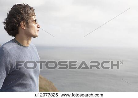 Young man looking at sea View Large Photo Image Stock Photography - Young man looking at sea. Fotosearch