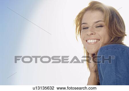 Young woman against clear sky (portrait, low angle view) View Large Photo Image Stock Image - Young woman against clear sky (portrait, low angle view). Fotosearch