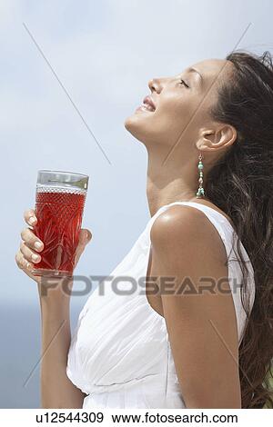 Young woman having juice View Large Photo Image Stock Photo - Young woman having juice. Fotosearch