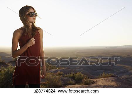 Young woman in dress and sunglasses on barren landscape, Arizona, USA View Large Photo Image Picture - Young woman in dress and sunglasses on barren landscape, Arizona, USA. Fotosearch