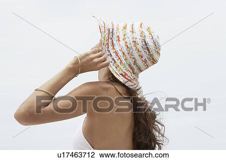 Stock Image - Young woman wearing hat. Fotosearch