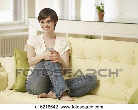 Stock Image - Portrait of Young Woman on Sofa. Fotosearch