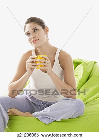 Young woman holding mug and day dreaming View Large Photo Image Stock Photography - Young woman holding mug and day dreaming. Fotosearch