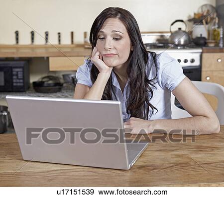 Bored Mid-Adult Woman Using Laptop View Large Photo Image Stock Photo - Bored Mid-Adult Woman Using Laptop. Fotosearch