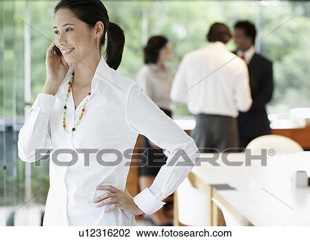 Stock Image - Businesswoman on phone in boardroom. Fotosearch