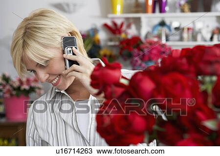 Female florist on cell phone View Large Photo Image Stock Image - Female florist on cell phone. Fotosearch