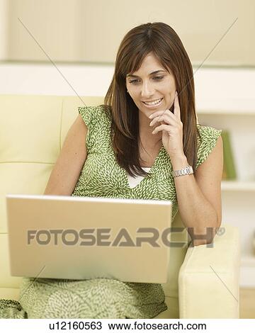 Mid-Adult Woman Using Laptop on Sofa View Large Photo Image Stock Image - Mid-Adult Woman Using Laptop on Sofa. Fotosearch