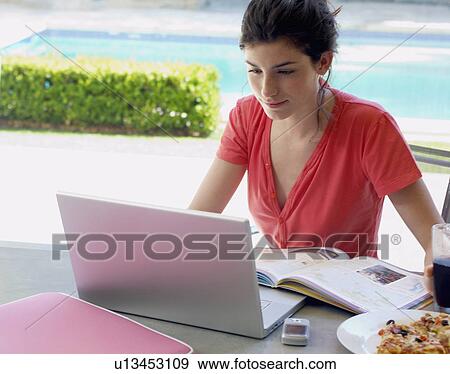 Woman studying and using laptop, snack on table (high angle view) View Large Photo Image Stock Photo - Woman studying and using laptop, snack on table (high angle view). Fotosearch