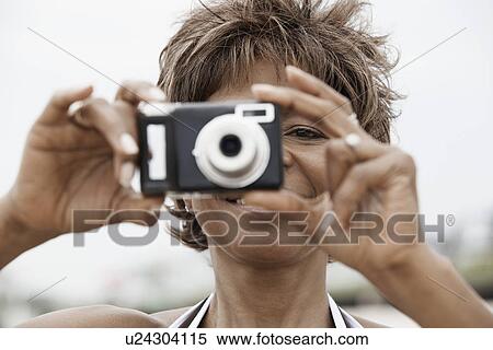 Stock Photography - Woman taking digital photograph. Fotosearch