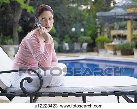 Woman talking on cell phone near swimming pool View Large Photo Image Stock Image - Woman talking on cell phone near swimming pool. Fotosearch