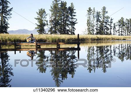 Teenage boy playing acoustic guitar by lake, Cape Town, South Africa View Large Photo Image Stock Photograph - Teenage boy playing acoustic guitar by lake, Cape Town, South Africa. Fotosearch