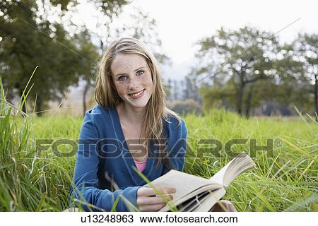 Teenage girl reading book in field View Large Photo Image Stock Image - Teenage girl reading book in field. Fotosearch