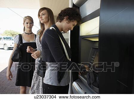 Teenage girls at cash machine View Large Photo Image Picture - Teenage girls at cash machine. Fotosearch