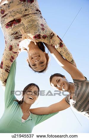 Three young women huddling (directly below) View Large Photo Image Stock Photo - Three young women huddling (directly below). Fotosearch
